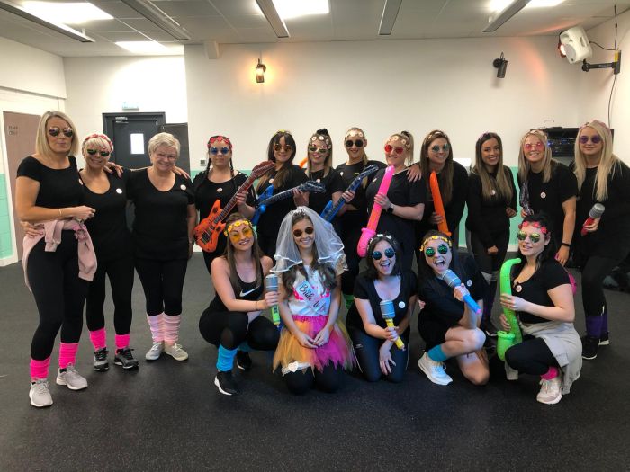 Group of women in 80s costume enjoying hen party dance class at Glasgow Dance Centre studio