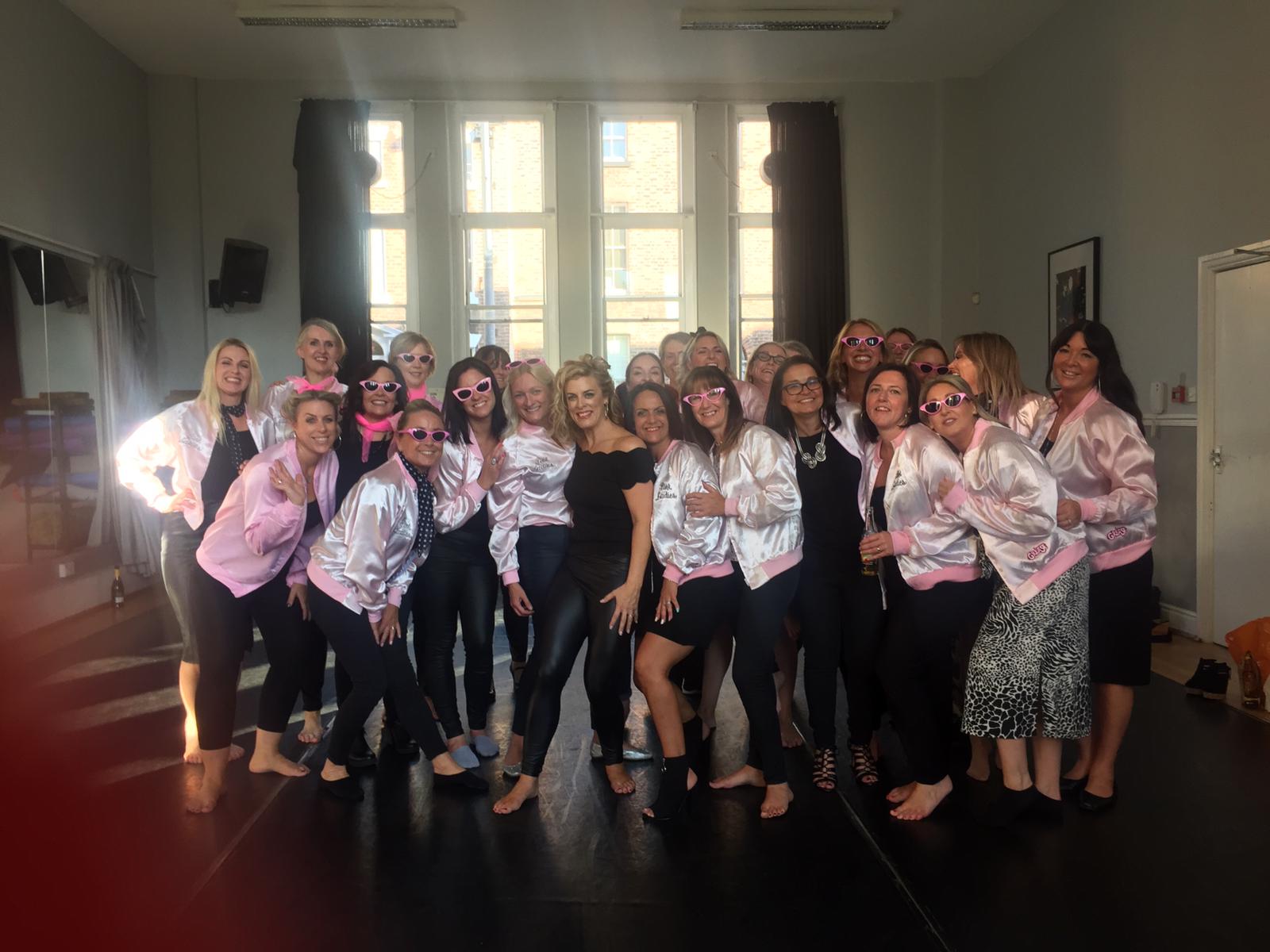 Happy hens in Pink Ladies outfits celebrating Grease themed hen party Glasgow city centre